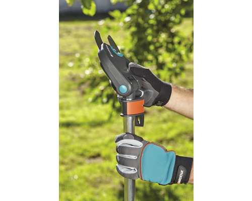 Tuinschaar met steel in gebruik, vastgehouden door tuinhandschoenen.