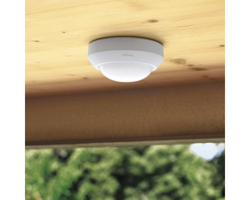 Plafondsensor voor bewegingsdetectie onder een houten plafond