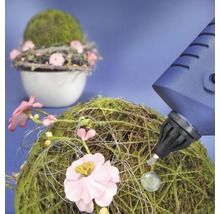 Decoratie van mosballen en bloemen wordt versierd met een lijmpistool