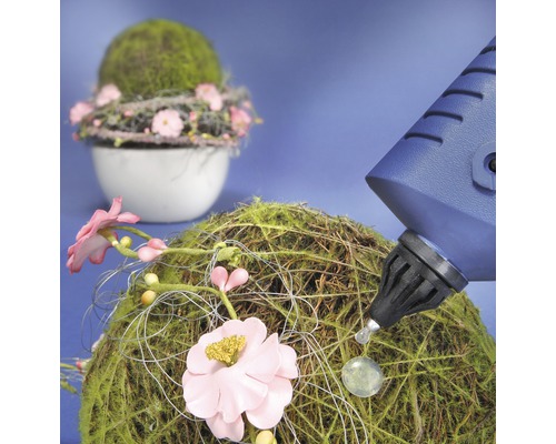 Decoratie van mosballen en bloemen wordt versierd met een lijmpistool