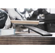 Draadborstel met houten handvat reinigt een metalen vijl