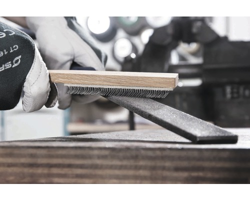 Draadborstel met houten handvat reinigt een metalen vijl