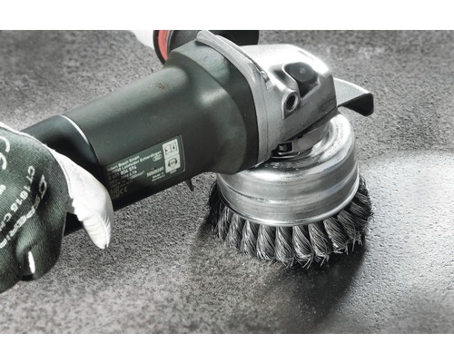 Draadborstel bevestigd aan een slijpmachine in gebruik