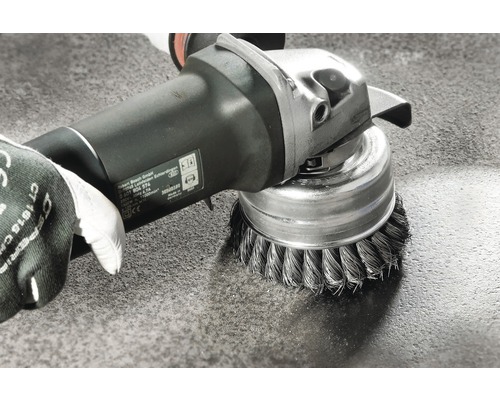 Draadborstelbevestiging op een slijpmachine tijdens het reinigen van een oppervlak
