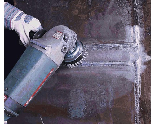 Een hand met een handschoen schuurt een metalen oppervlak met een schuurmachine.