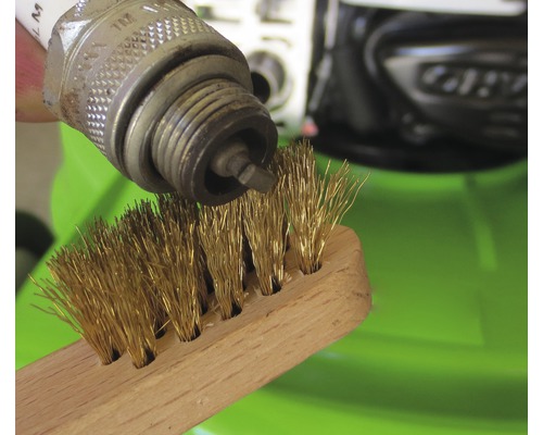 Bougie wordt schoongemaakt met een draadborstel.