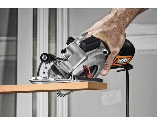 Hand die een Worx handcirkelzaag gebruikt om een stuk hout te zagen