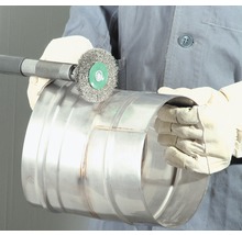 Een persoon gebruikt een staalborstel om een metalen buis schoon te maken.