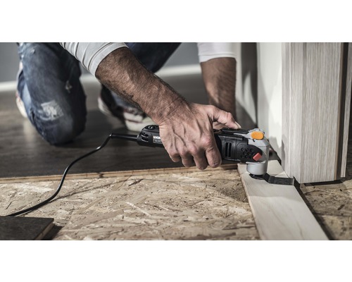 Man gebruikt multifunctioneel gereedschap om een stuk hout te snijden