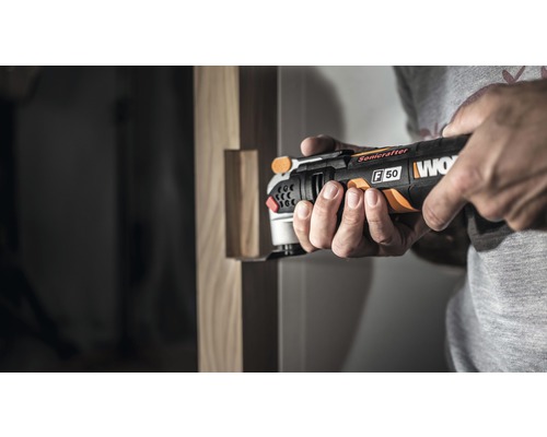 Een man gebruikt een Worx multitool voor houtbewerking.