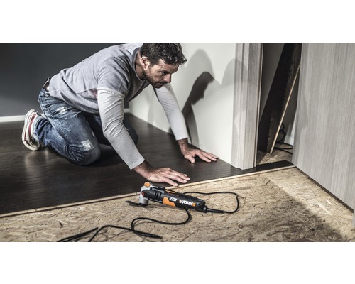Een man werkt met een Worx multifunctioneel gereedschap aan een vloer.