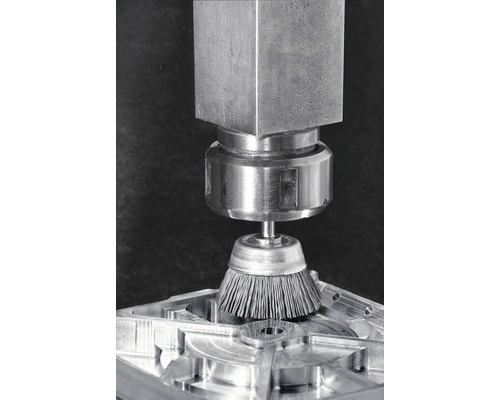 Metalen borstel in gebruik op een werkstuk