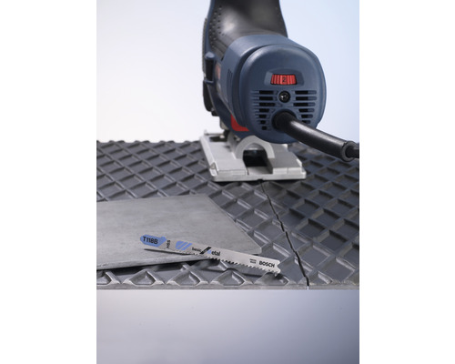 Decoupeerzaag en zaagblad die een tegel doorsnijden