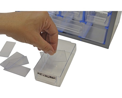 Persoon sorteert transparante hoezen in lade-elementen