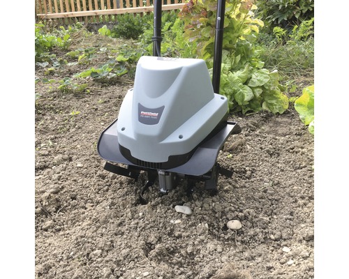 Motorfrees in gebruik in een tuinbed.