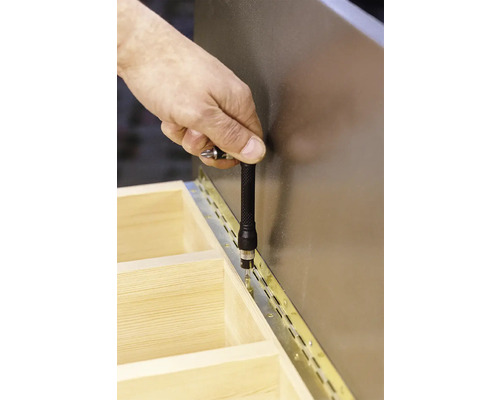 Hand schroeft scharnier op houten structuur met schroevendraaier