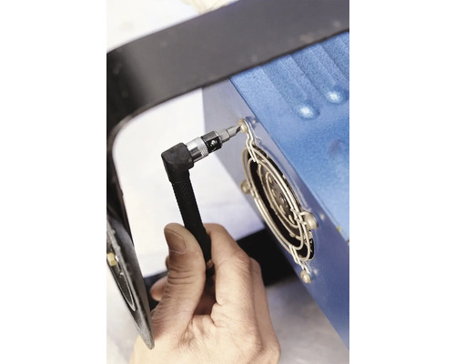 Een persoon bevestigt een schroefbit aan een koellichaam.