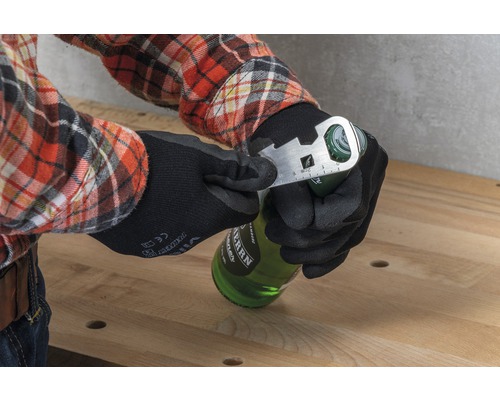 Een persoon met werkhandschoenen opent een fles met een multifunctioneel gereedschap.