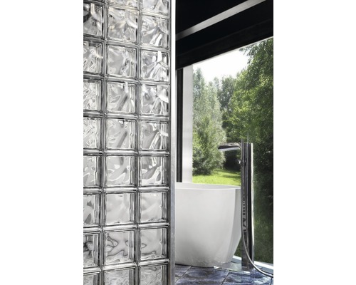 Badkamer met glazen bouwsteenmuur en bad