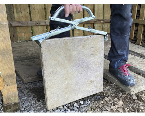 Man tilt stoeptegel op met stenenklem