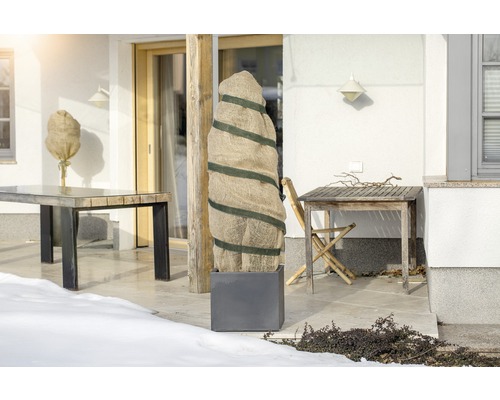 Terras met beschermhoezen voor planten en tuintafels in de winter.