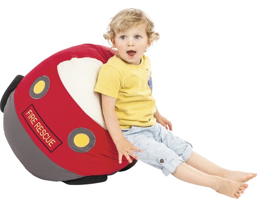 Een kind zit op een zitzak in de vorm van een brandweerauto.