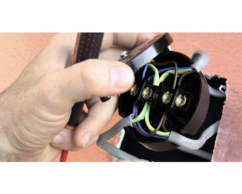 Elektricien installeert een stopcontact met een schroevendraaier