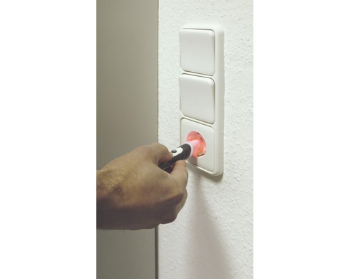 Hand die stopcontact controleert met spanningstester