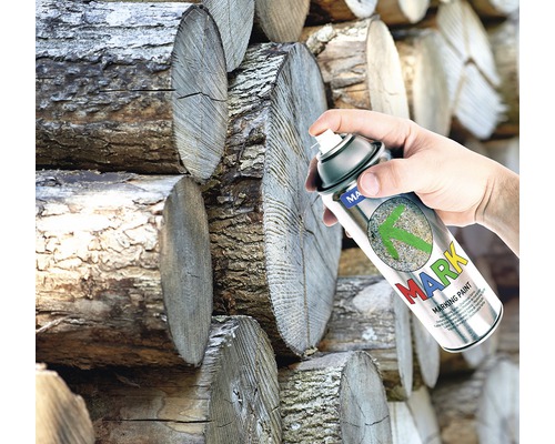 Een hand spuit markeerverf op hout.