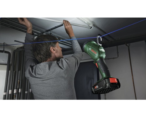 Man bevestigt Bosch werklamp met haak aan een touw in een kelder