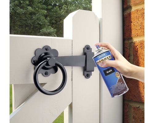 Spuitverf wordt aangebracht op een tuinpoort