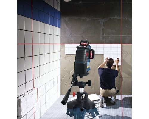 De scène toont een tegelzetter die werkt met een lijnlaser om tegels uit te lijnen.