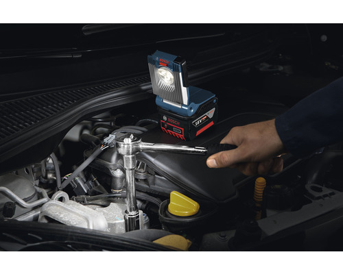 Accuwerklamp in gebruik op een automotor met een vakman die een sleutel gebruikt