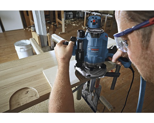 Ambachtsman in werkplaats die hout bewerkt met een bovenfrees