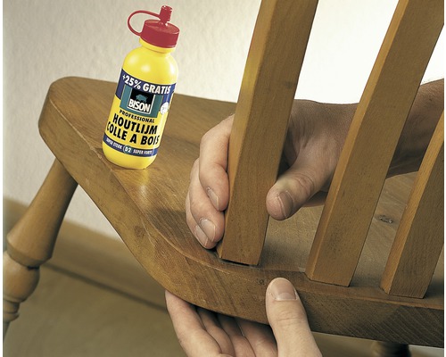 Iemand repareert een houten stoel met houtlijm van Bison.