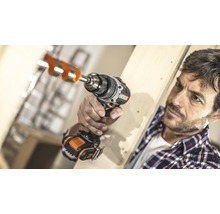 Man boort een gat in een houten plank met een accuschroefboormachine