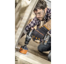 Een man boort een gat in een houten plank met een accuboormachine.