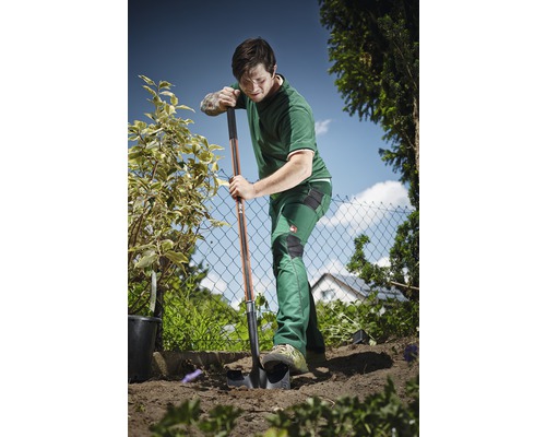 Tuinman gebruikt een spade om in de tuin te graven.