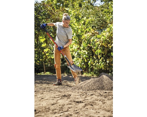 Vrouw werkt met spade in de tuin