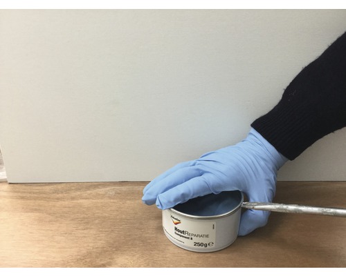 Houtreparatieset Blik met spatel wordt vastgehouden door een hand