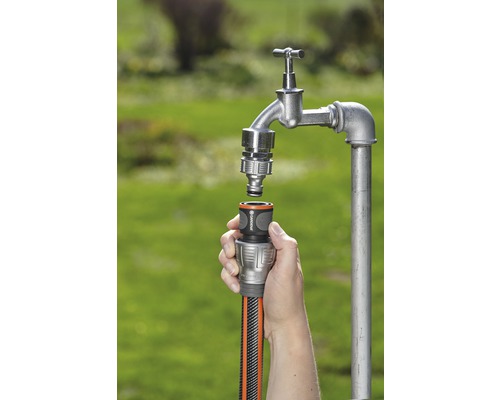 Tuinslangaansluiting met één hand op een waterkraan bevestigd