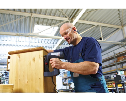 Ambachtsman bevestigt hout met een elektrische tacker