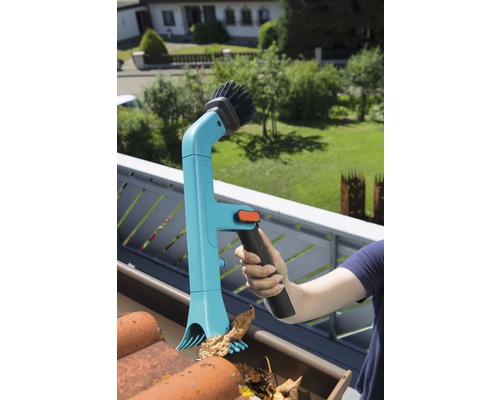 Persoon reinigt dakgoot met dakgootreiniger