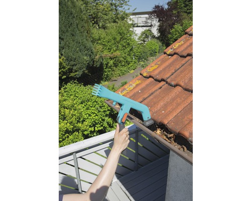 Persoon reinigt dakgoot met dakgootreiniger