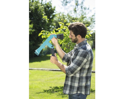 Een man in de tuin gebruikt een fruitplukker voor de oogst.