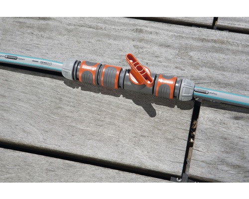 Gardena regelventiel verbonden met tuinslang op een houten tafel