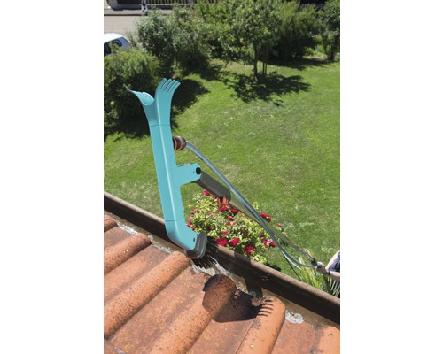 Dakgootreiniger in gebruik op een dak