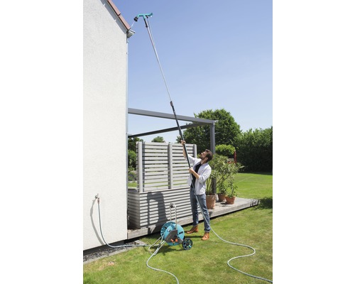 Man reinigt dakgoot met dakgootreiniger aan telescopische steel