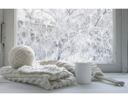 Decoratieve folie op raam met breigoed en drankje