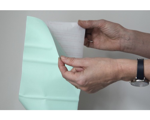 Een persoon verwijdert de beschermfolie van een folie.